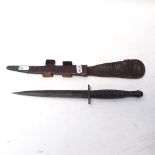 A Fairbairn Sykes style commando fighting knife, ribbed grip with leather scabbard, unmarked,
