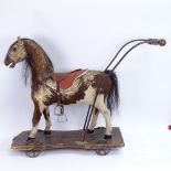 An antique German child's push-along horse toy, pony-skin covered with horse hair mane and tail,