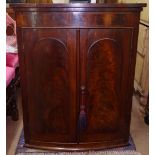 A George III mahogany bow-front hanging corner cupboard, with 2 panelled doors, W75cm