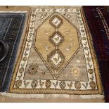 A brown and cream ground wool rug, with lozenge and animal decoration, 210cm x 116cm