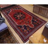 A red ground wool Persian design rug, 265cm x 142cm