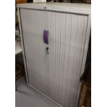 A metal filing cupboard with 2 tambour doors, label for J G Group, W100cm, H144cm