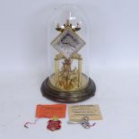 A Kundo brass 400-day clock under glass dome, with original instructions, label and key, overall