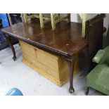 An Edwardian mahogany wind-out dining table with single spare leaf, raised on cabriole legs,