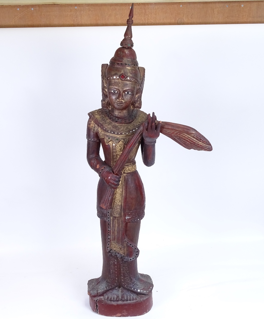 A large Burmese carved lacquered and gilded wood Nat figure on plinth, overall height 93cm