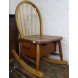 A mid-century child's Ercol stick-back rocking chair, with drawer to the underside of the seat