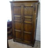 An Ipswich oak design hall cupboard, with 2 linenfold and carved panelled doors, W107cm