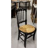 An Antique stained black side chair, with carved back and rush seat