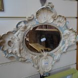 A French mirror with ceramic frame with moulded shells and cupids, length 44cm