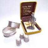 A pair of engine turned silver napkin rings, 3 silver thimbles, and a hallmarked silver figure of