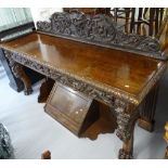 An impressive Victorian oak serving table, with a raised acanthus leaf lion mask and bird raised