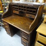 A 1920s oak roll-top pedestal writing desk, with fitted interior and 6 short drawers, W122cm