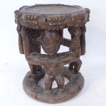 An African Tribal carved hardwood ceremonial seat, figural supports, seat height 34cm