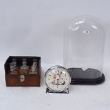 A glass dome and ebonised wood base, a leather-cased fitted set of glass perfume bottles, and a