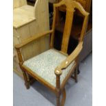 An Arts and Crafts oak elbow chair, with stylised shaped stretcher