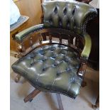 A reproduction studded green leather-upholstered swivel desk chair