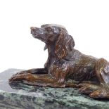 A small patinated bronze reclining dog on green marble plinth, unsigned, plinth length 15cm