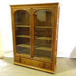 A French cherrywood 2-door bookcase, circa 1920s, arch glazed panelled doors with floral carved