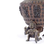 An Indian bronze and silver inlaid lamp base supported by 3 figures, height excluding fitting 29cm