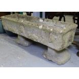 A weathered concrete rectangular garden trough on stand