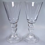 A pair of glass goblets on domed plinths, 23cm