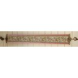 A machine embroidered tapestry panel curtain tieback with cast-brass mounts, overall length 133cm