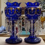 A pair of gilded blue glass table lustres with arrowhead drops, 39cm