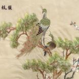 An Oriental silk embroidered picture, depicting peacock in tree tops, 41cm x 65cm, framed