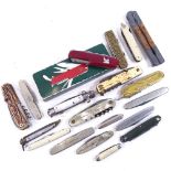 A collection of various penknives and Swiss Army knives, including some stag horn-handled