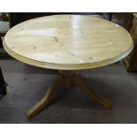 A modern circular polished pine kitchen table on tripod base, W103cm