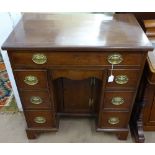 A late Victorian mahogany and satinwood-strung knee-hole writing desk, in Queen Anne style, with