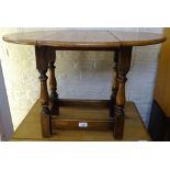 A small oak oval swivel-top drop leaf occasional table