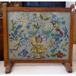 A 1920s oak-framed fire screen with needlework panel