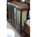 A 1920s mahogany serpentine-front display cabinet with 2 glazed doors, W120cm
