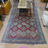 A large Antique red ground Persian design carpet, with symmetrical pattern and lozenge panel,