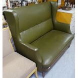 A green rexine upholstered wingback settee, on carved melon legs