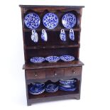 A Vintage stained pine doll's house dresser, with tin-glaze blue and white tea set, dresser height