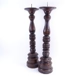 A pair of 18th century turned oak pricket candlesticks, height 68cm