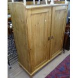 A polished pine larder cupboard with fitted shelves and 2 panelled doors, on bun feet, W111cm