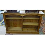 A polished pine side by side open bookcase, W151cm