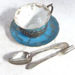 An Edwardian Staffordshire coffee cup and saucer, in a stylised scrolled and pierced silver stand,