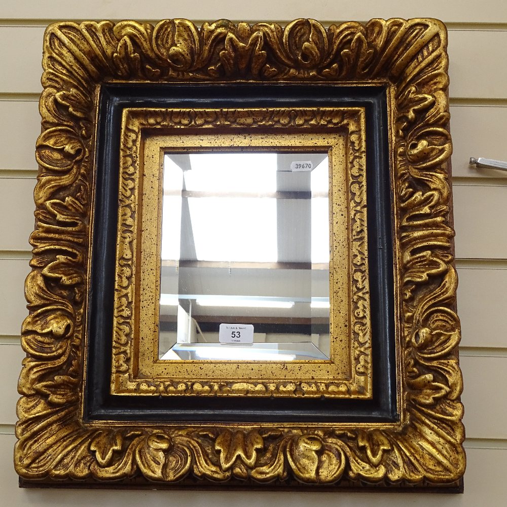 An ornate gilt-framed bevelled-edge wall mirror, frame height 52cm