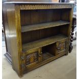 An Ipswich oak design open bookcase, with carved cupboards to the base, on stile supports, W110cm