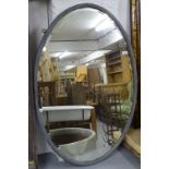 An early 20th century reeded and painted frame oval bevelled-edge wall mirror