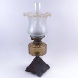 A 19th century oil lamp, with iron base, round glass font, frosted frilled shade and clear glass