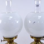 A pair of brass Duplex oil lamps, with milk glass shades and clear chimneys, overall height 50cm (2)