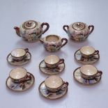 A Satsuma doll's tea service, with painted designs including teapot, height 5.5cm