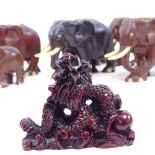 A set of carved hardwood elephants, and a resin dragon ornament, largest height 8cm