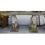 A weathered concrete curved garden bench on lion supports, W120cm