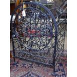 A wrought-iron arch-top wine cabinet